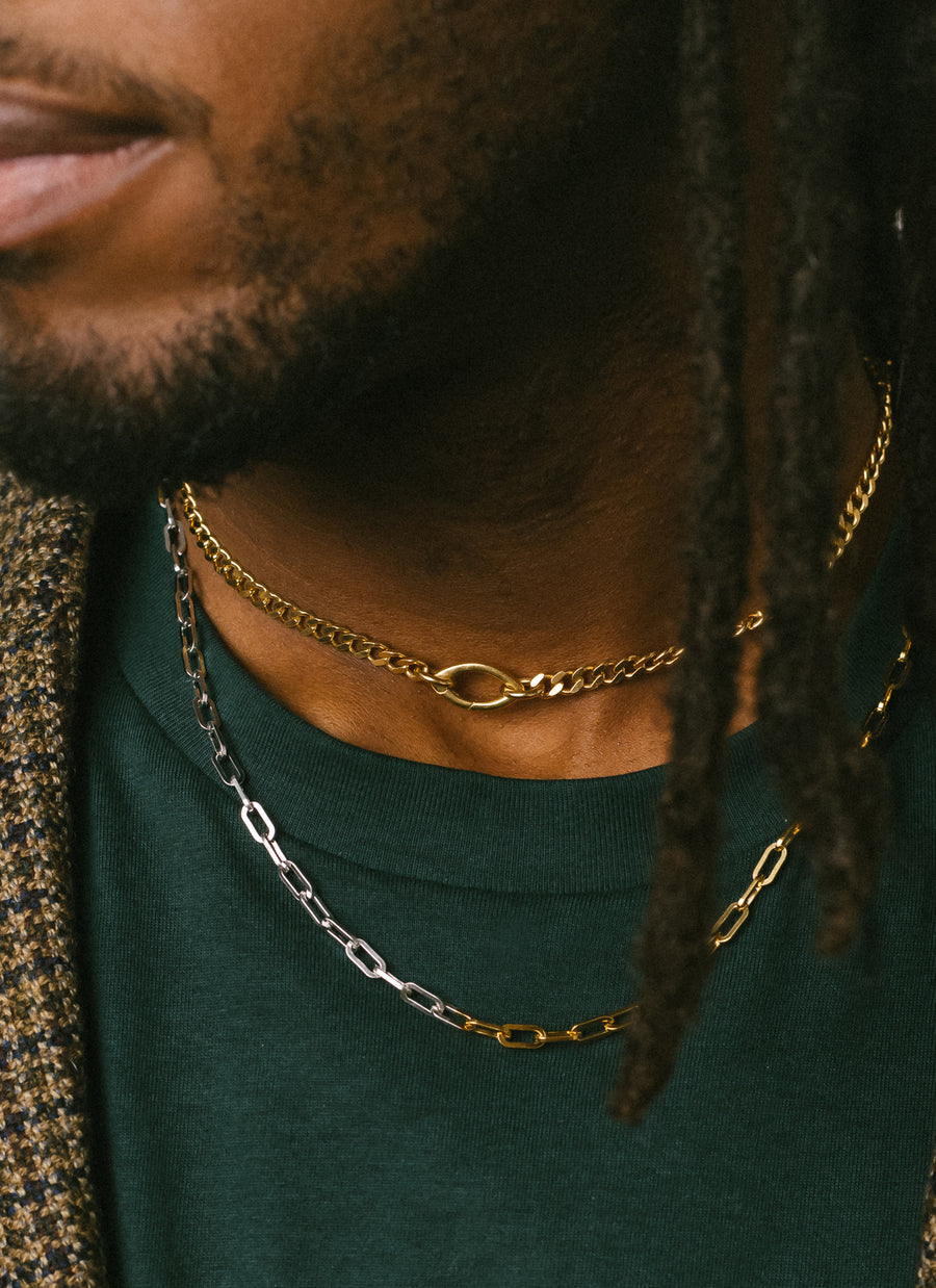Male model wears the genderless Gramercy curb chain necklace from RIVA New York in gold vermeil layered with the Astor Two Tone Necklace