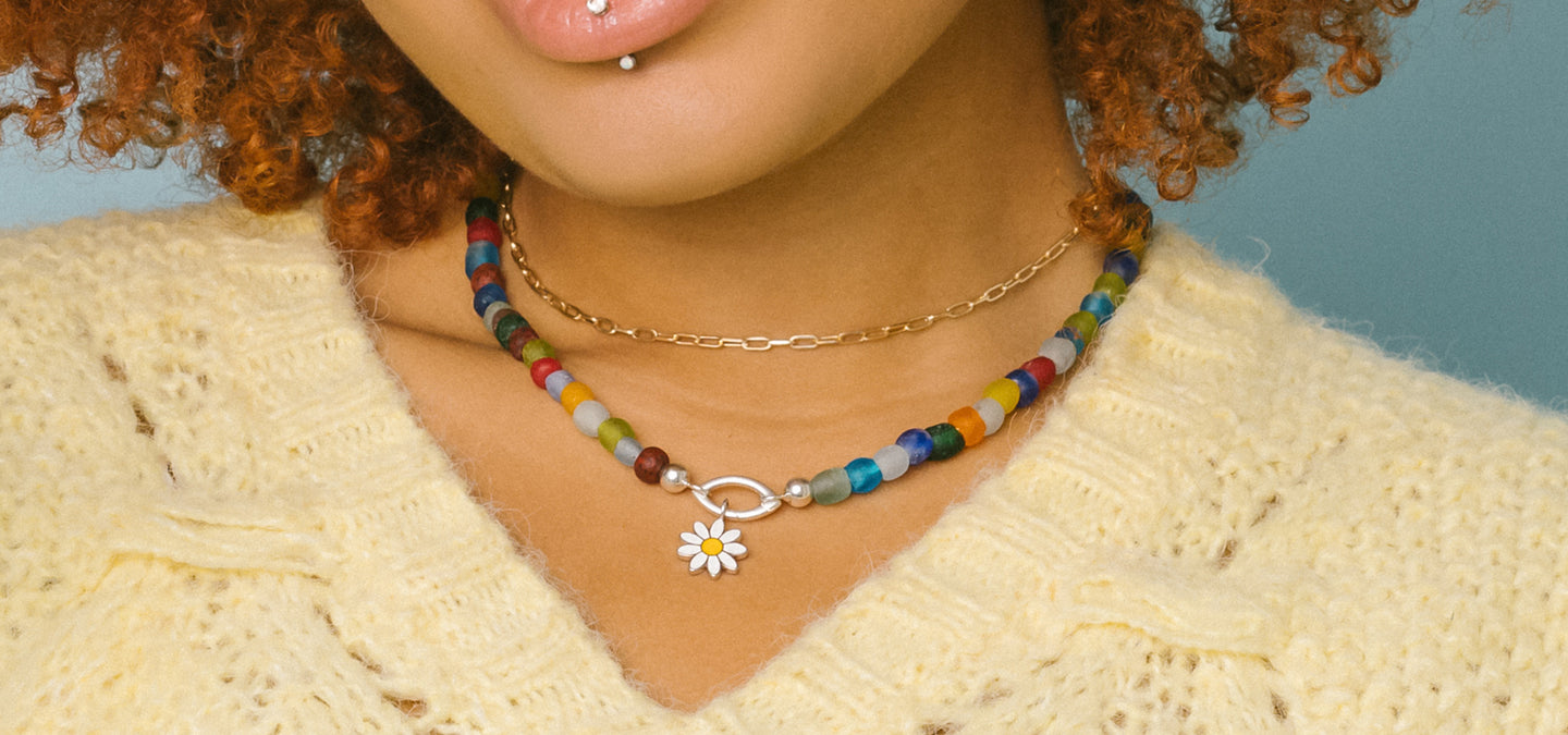 Model wearing the Luna multicolor glass bead necklace, marquise-shaped Invisible Clasp and daisy enamel charm from RIVA New York's Expression Collection