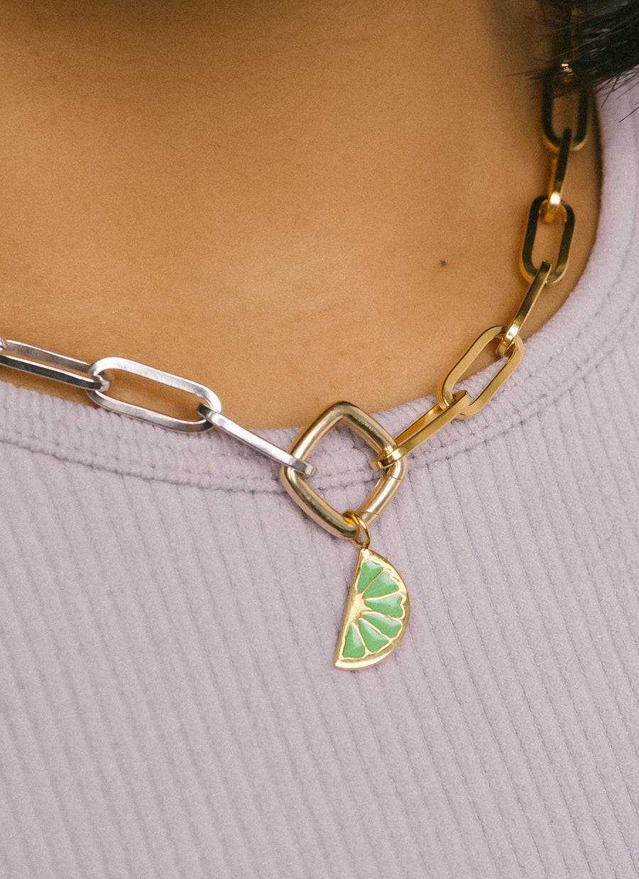 Closeup of citrus wedge charm in green enamel and gold vermeil from RIVA New York jewelry