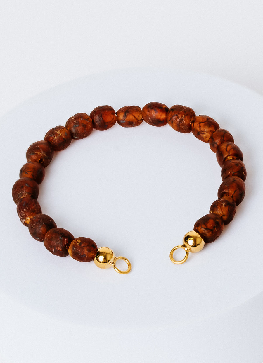 The Cobble bead bracelet from RIVA New York with gold vermeil accents, featuring speckled brown recycled glass beads from the Krobo people in Ghana; needs to be paired with an Invisible Clasp