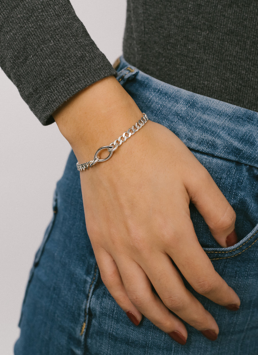 Female hand model wearing the sterling silver unisex Gramercy curb chain bracelet from RIVA New York