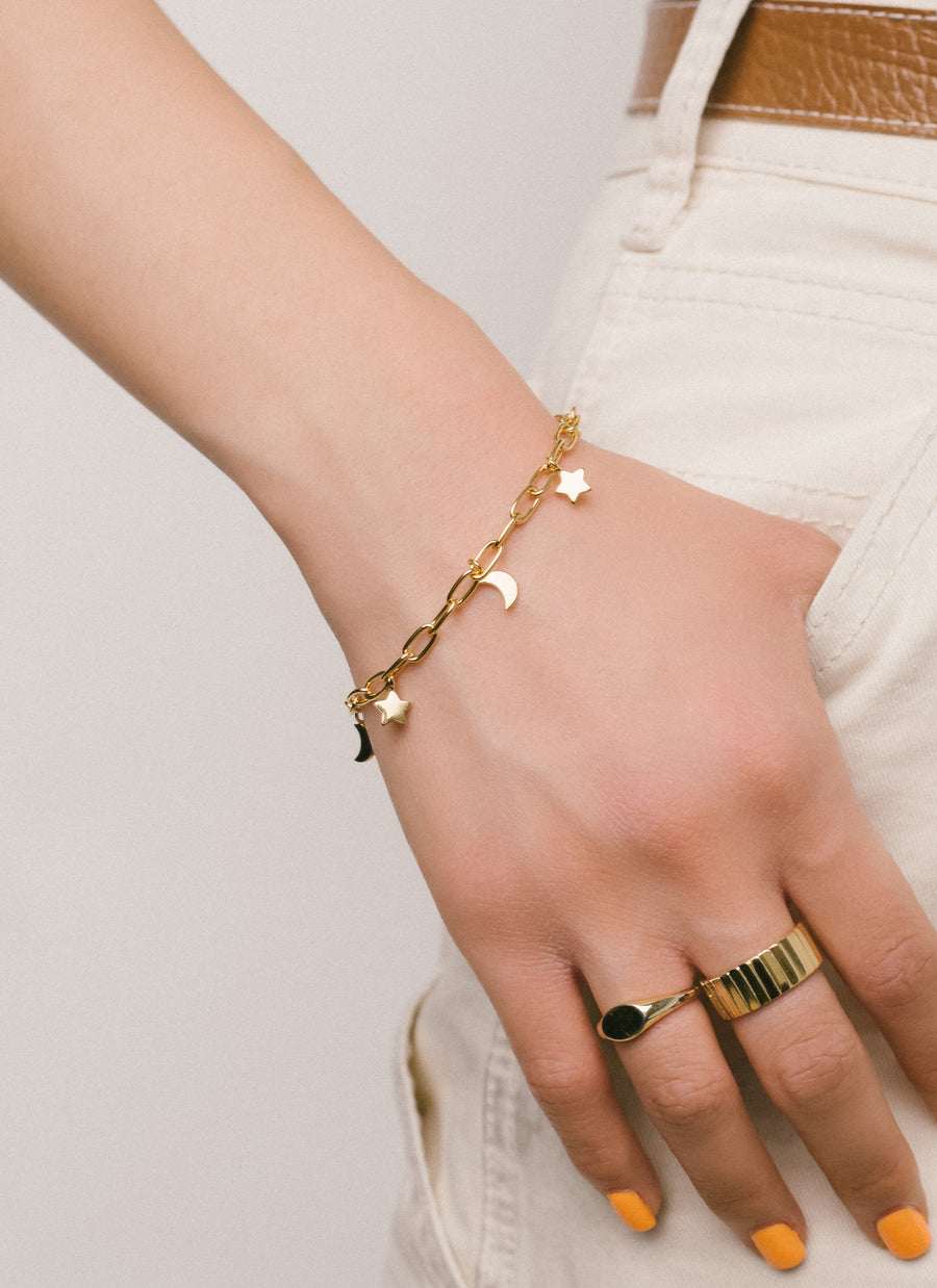 Charm bracelet from RIVA New York featuring moon and star charms dangling from a rounded wire paper clip chain, in gold vermeil