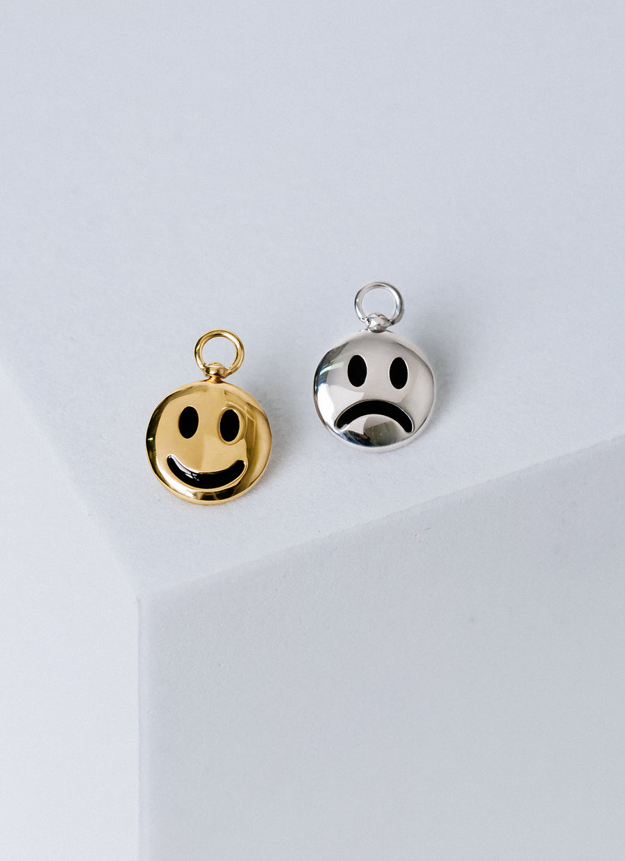 Moody Swivel Charms from RIVA New York featuring a happy face on one side and a sad face on another, in gold vermeil and sterling silver