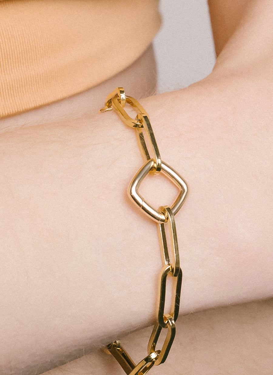 The cushion-shaped Invisible Clasp by RIVA New York in 14K yellow gold, used as bracelet closure