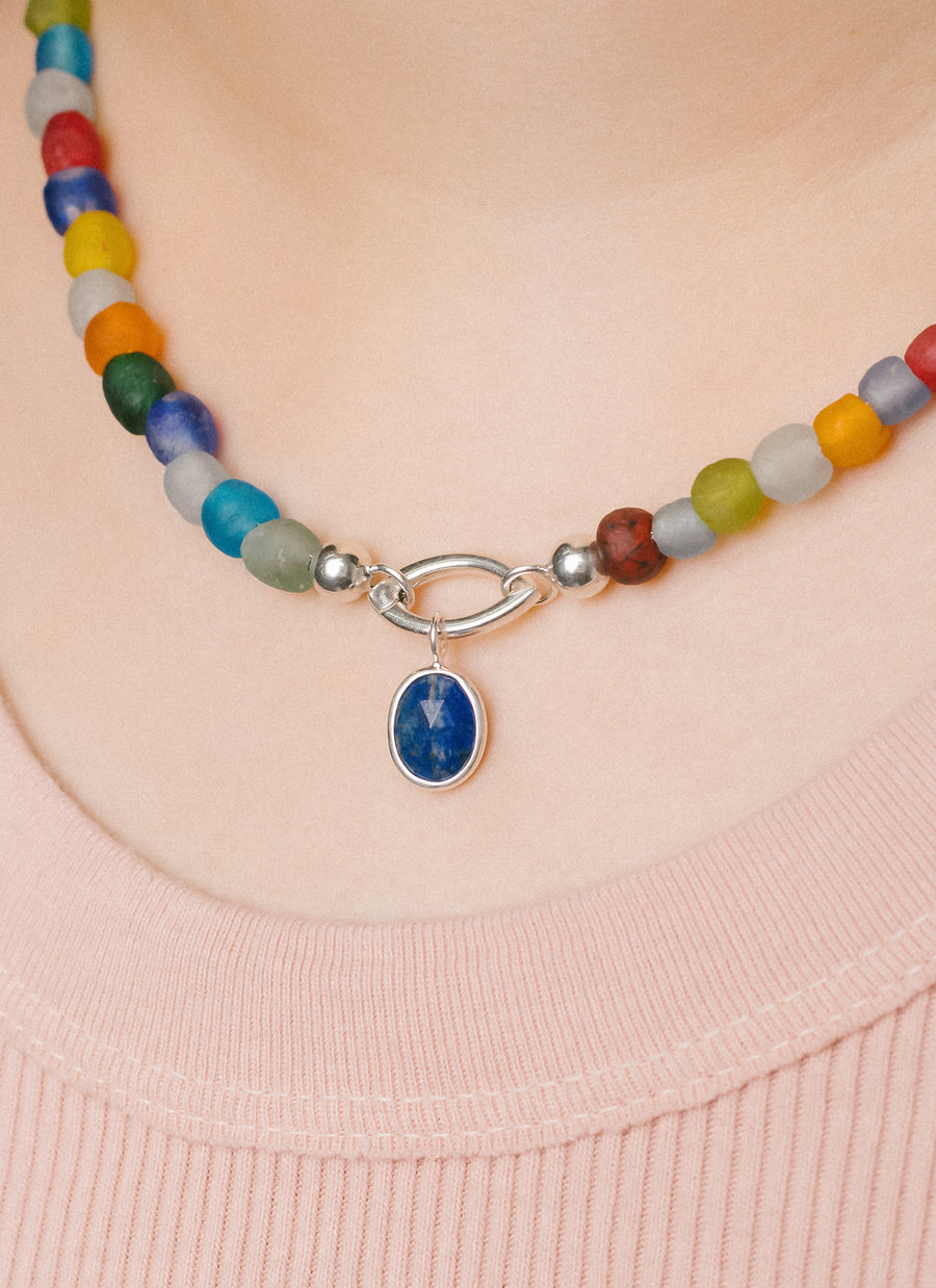 Oval lapis lazuli charm in sterling silver from RIVA New York worn with marquise shaped Invisible Clasp and Luna multicolor recycled glass bead necklace