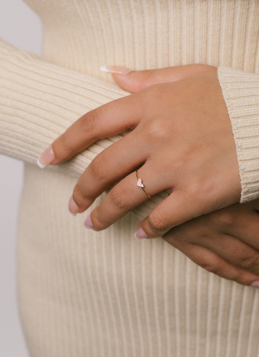 Hand model wearing pink enamel heart stacker ring from RIVA New York