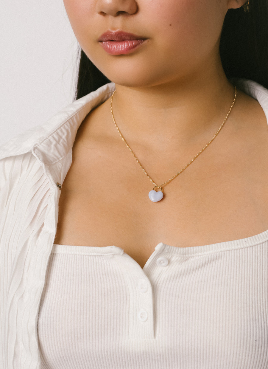 Female model wearing the Chalcedony Heart Lock Pendant Necklace from RIVA New York