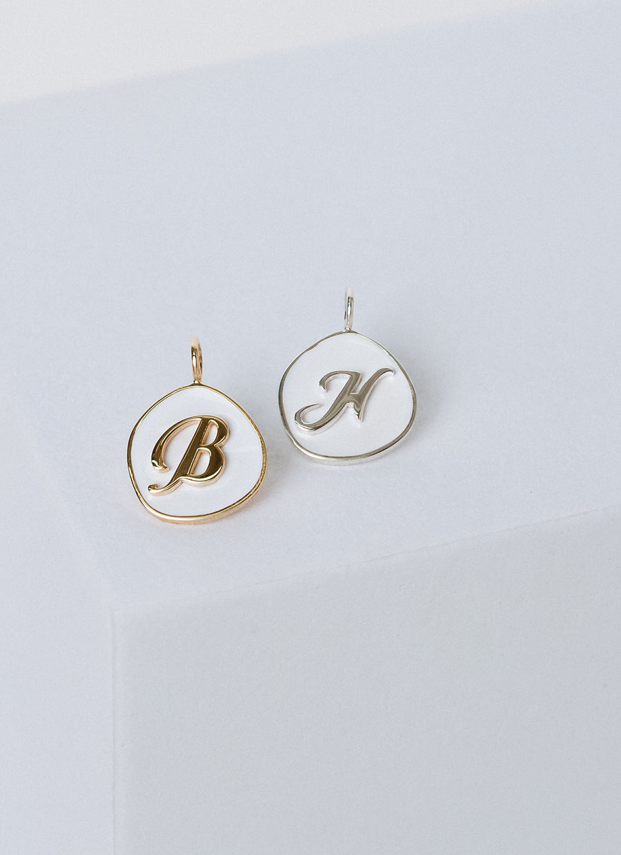 Script letter white enamel charm from RIVA New York, available in silver, gold vermeil, and 14K yellow gold