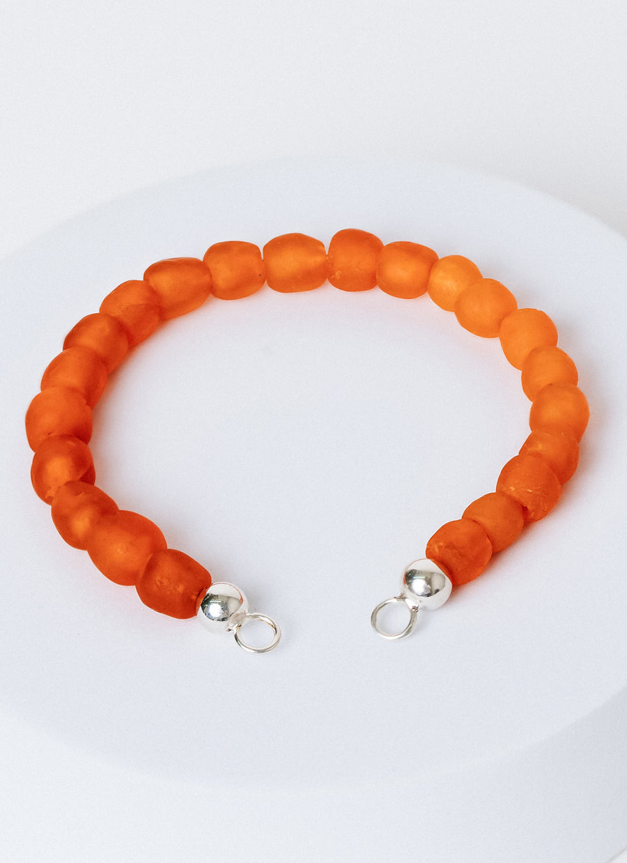The Sunset bead bracelet from RIVA New York, made of orange recycled glass beads from the Krobo people of Ghana; needs to be paired with an Invisible Clasp